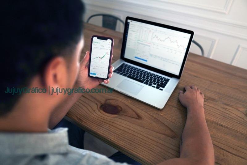 Photo by Joshua Mayo person holding iphone 6 near macbook pro Reseñas Brokers: Protegiendo tus inversiones en el Mundo Financiero