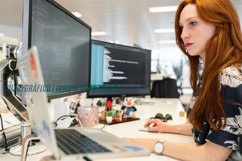 woman in green shirt sitting in front of computer