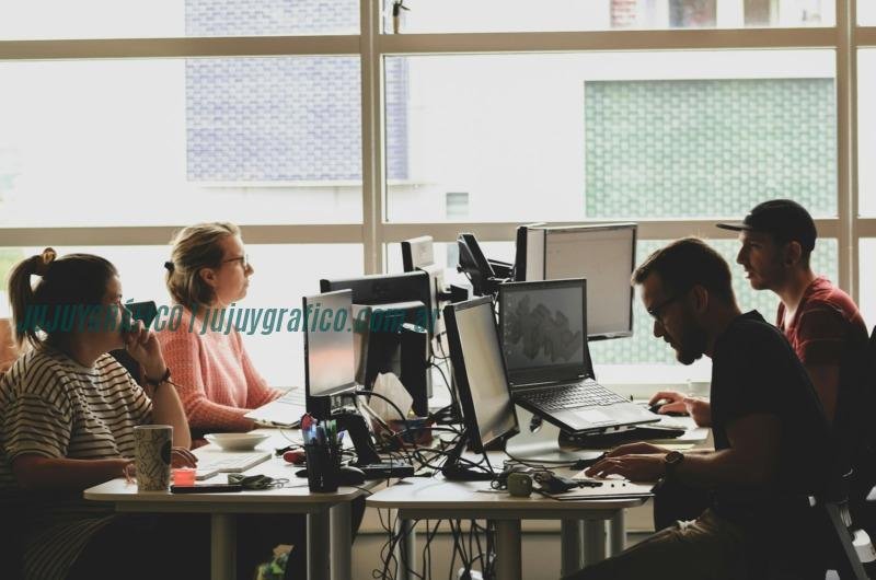 mujer con camisa rosa sentada delante de un ordenador portátil negro Inteligencia Artificial en 2025: Transformando el comercio y la salud